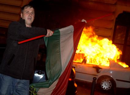 Беспорядки в Венгрии
A Hungarian right-wing protester waves a national flag in front of a burning TV car as demonstrators storm the headquarters of the Hungarian State Television during an escalating protest against Hungary\\\'s socialist government in Budapest, Hungary, early Tuesday, Sept. 19, 2006. The protest started on Sunday evening calling for Prime Minister Ferenc Gyurcsany to resign. Gyurcsany has admitted saying that his party lied to the public to win April\\\'s general election. Gyurcsany\\\'s admission came after Hungarian radio played a tape of a meeting he had with his Socialist MPs a few weeks after the election. Hungarian President Laszlo Solyom declared Monday, that the country is in moral crisis. (AP Photo/Bela Szandelszky)