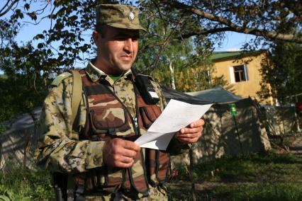 Пограничник читает письмо из дома на заставе в Осетии