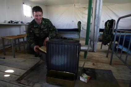 Пограничник топит печку на заставе в Осетии