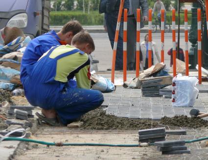 рабочие  ремонт  дорог кладка брусчатки