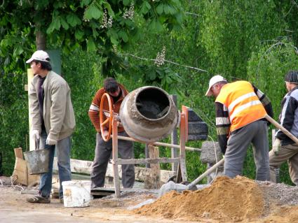 рабочие гастарбайтеры мешают бетон