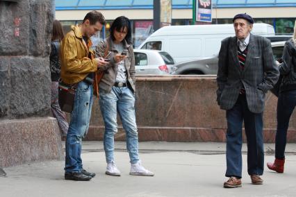 Жанровое фото с Тверской улицы, Москва, 17 июня 2010 года. Старые. Молодые. Старики. Молодежь. Сотовый телефон. Мобильная связь.