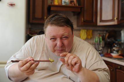 Актер Александр Семчев во время обеда у себя дома, 7 июля 2010 года. Палочки. Еда.