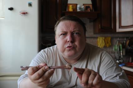 Актер Александр Семчев во время обеда у себя дома, 7 июля 2010 года. Палочки. Еда.