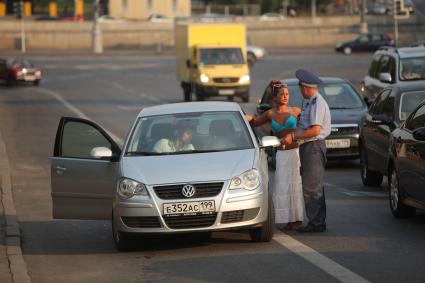 Жара в Москве, 20 июля 2010 года. Жанровые фото с из центра города. Автомобили. Движение на дороге. ГАИ. ГИБДД. Нарушение правил. Женщина за рулем. Штраф.