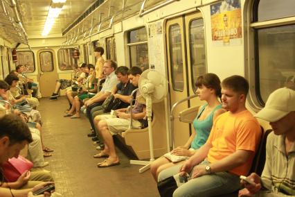 Пассажиры московского метро в поезде, 31 июля 2010 года. Климатическая техника. Вентилятор. Духота. Жара. Лето.
