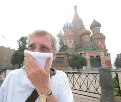 Смог от лесных пожаров на Красной площади Москвы, 4 августа 2010 года. Лесной пожар. Дым. Дымка. Гарь. Экологимя. Марлевая повязка. Маска. Турист.