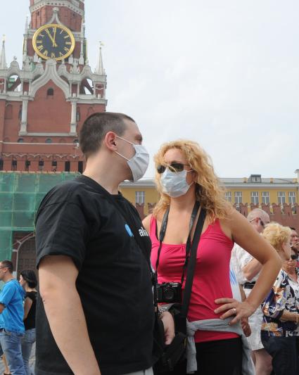 Смог от лесных пожаров на Красной площади Москвы, 4 августа 2010 года. Лесной пожар. Дым. Дымка. Гарь. Экология. Марлевая повязка. Маска. Туристы. Иностранцы.