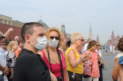 Смог от лесных пожаров на Красной площади Москвы, 4 августа 2010 года. Лесной пожар. Дым. Дымка. Гарь. Экология. Марлевая повязка. Маска. Туристы. Иностранцы.
