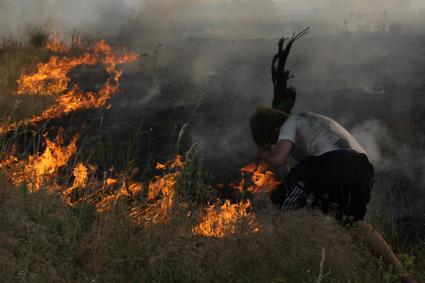 21.07.2010 Самарская область, село Усолье. Мальчик тушит траву веткой.