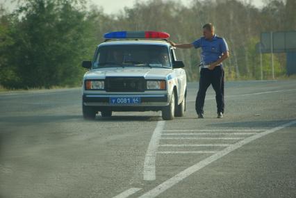 Гаишник волно стоит посреди дороги, высматривая нарушителей, 16 августа 2010 года. ГАИ, ГИБДД, милиция, мент, автомобиль, дорога, дорожная разметка, нарушение, ПДД, правила дорожного движения, превышение скорости, штрафы, взятки