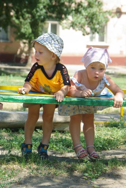 Дети дошкольного возраста играют во дворе дома, 13 июля 2010 года дети, детский сад, мальчик и девочка, отношения, детская любовь, игра, лавочка, лето, детство, первая любовь, друзья.