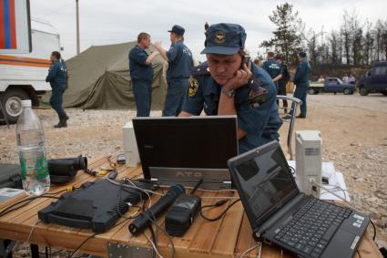 03.09.2010 Тольятти, Россия. Спасатель МЧС в штабе налаживает связь.