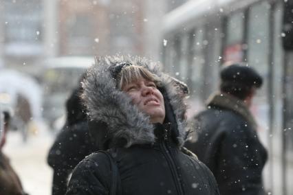 19.02.2010 Самара, Россия. Женщина смотрит вверх на идущий снег