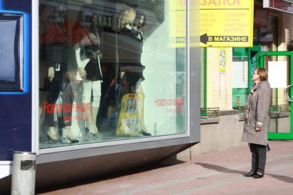 Жанровая съем ка на улицах Москвы,  27 сентября 2010 года.  Жительница города рассматривает витрину модного мгазина. Мода. Торговля. Одежда. Витрина. Женщины.