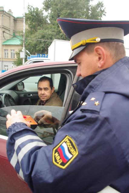 Инспектор ДПС проверяет тонировку передних стекол машины, 30 сентября 2010 года, Саратов. Тонировка, штраф, увеличение штрафов, новый закон, прибор для определения тонировки, светопропускаемость, автомобиль, мент, ГАИ, ГИБДД, водитель, нарушение закона