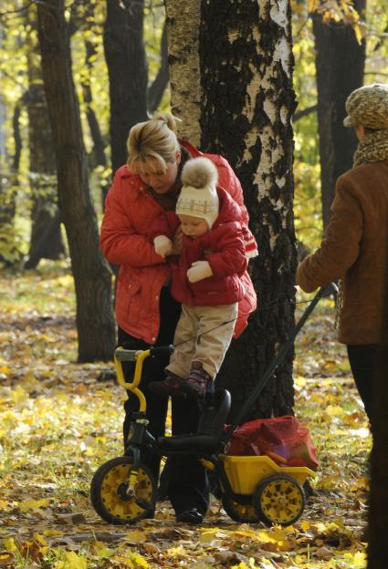 20 октября 2009 года. Осень. Женщина сажает ребенка на велосипед.