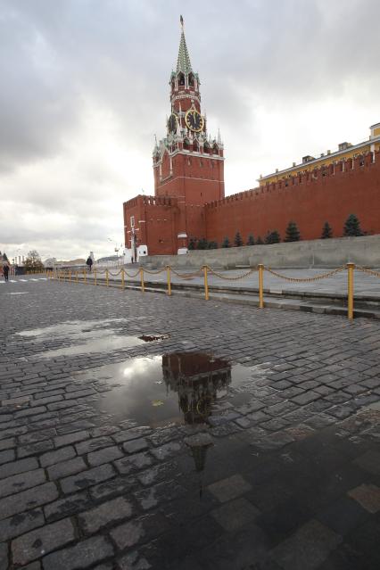 Дата съемки : 15.10.2010. Красная площадь . На фото : Спасская башня с курантами и кремлевская стена - отражение в луже , брусчатка