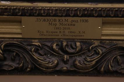 Дата съемки : 18.10.2010. Портрет Юрия Лужкова расположен в .мэрской. галерее . Портрет  стал двадцатым по счету в мэрском иконостасе . на фото: надпись на портрете Лужкова