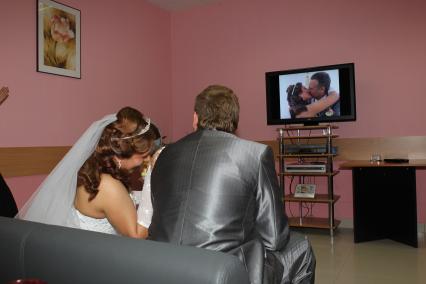 Дата: 26.06.2010, Время: 11:43. Молодая пара, теперь уже жена с мужем смотрят запись торжественной церемонии бракосочетания по телевизору.