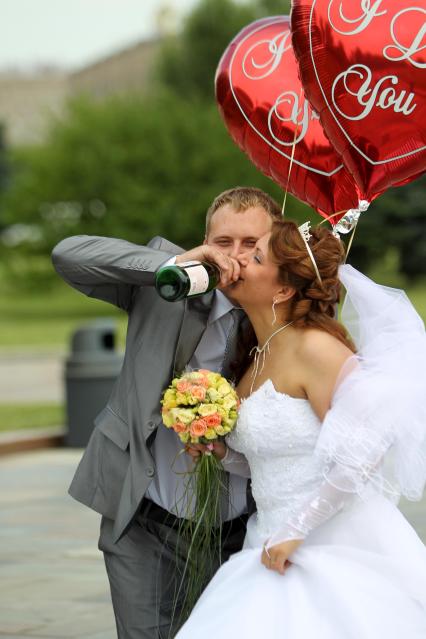 Дата: 26.06.2010, Время: 14:06. Молодая пара выпивает / пьет из горлышка шампанское.