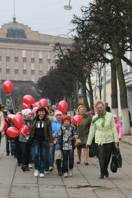 Дата: 17.04.2010, Время: 13:35. Группа детей с воздушными шарами идет по улице города в сопровождении взрослых.