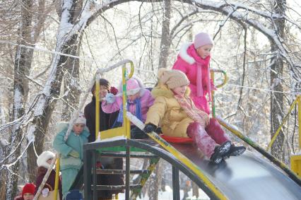 Дети с родителями катаются с горки, 20 декабря 2009 года. Саратов, зима, детские забавы, каникулы, дети, школьники, травмы, отдых, прогулки, развлечения, зимняя одежда, горка, детская площадка, родители, бабушка