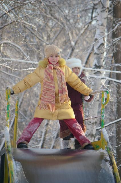 Дети катаются с горки, 20 декабря 2009 года. Саратов, зима, детские забавы, каникулы, дети, школьники, травмы, отдых, прогулки, развлечения, зимняя одежда, горка, детская площадка.