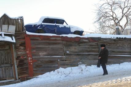Старое авто стоит на крыше деревянного дома, Саратов, 12 января 2010 года. Снег, зима, старое авто, автомобиль, машина, утилизация, металлолом.