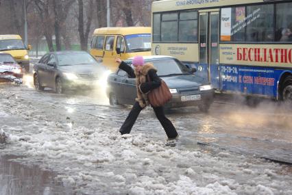 Оттепель зимой- под ногами снежная жижа, люди прыгают через лужи, 30 ноября 2011 года, Саратов. Оттепель, зима, плюсовая температура, снег, лужи, сугробы, пробка, люди, мокрые ноги, резиновые сапоги, дорога, простуда.