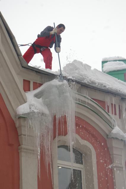Сбивание сосулек с крыши дома, 16 февраля 2010 года, Саратов. Сосульки, снег, промышленный альпинизм, рабочий, ЖКХ, коммунальные службы, лопата, зима, снаряжение альпиниста, крыша, очистка крыши, обледенение.