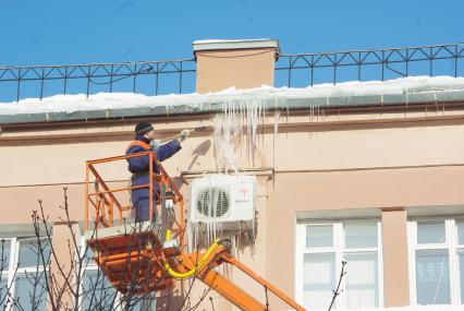 Сбивание сосулек с крыши дома, 16 февраля 2010 года, Саратов. Сосульки, снег, промышленный альпинизм, рабочий, ЖКХ, коммунальные службы, лопата, зима, снаряжение альпиниста, крыша, очистка крыши, обледенение.