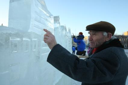 13.12.2010 Самара, Россия. Дед трогает ледяную скульптуру