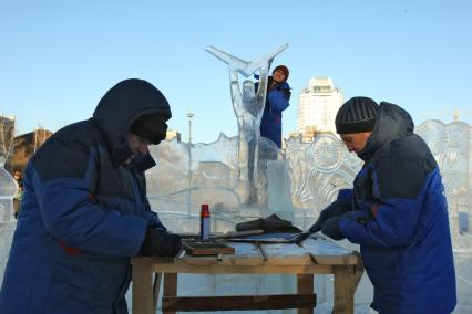 13.12.2010 Самара, Россия. Рабочий выпиливает ледяную скульптуру