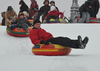 Дети катаются с горы зимой в парке.Дата съемки: 09.01.2011