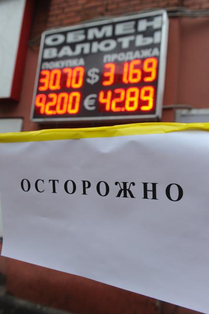 Табло обменного пункта на фоне вывески \"Осторожно!\"
23 ноября 2010.