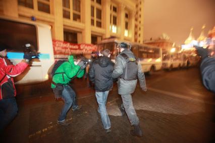 В Москве на Манежной площади прошел несанкционированный митинг националистически настроенной молодежи, приуроченный к событиям 11 декабря. На снимке: Сотрудник милиции под прицелом фотокамер проводит задержание радикально настроенного гражданина, провожает его до автозака. 11 января 2011 года.