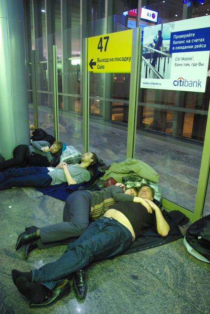 Предновогодний коллапс в аэропорту Шереметьево, 26 декабря 2010 года, Москва. Задержка рейса, ожидание рейса, багаж, чемодан, дорожная сумка, петешественник, аэропорт, аэрофлот, терминал, люди спят на полу.