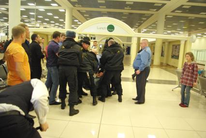 Предновогодний коллапс в аэропорту Шереметьево. Драка между сотрудниками аэрофлота и пассажирами, 26 декабря 2010 года, Москва. Задержка рейса, ожидание рейса, багаж, чемодан, дорожная сумка, петешественник, аэропорт, аэрофлот, терминал, люди спят на полу, милиция, омон, охрана.