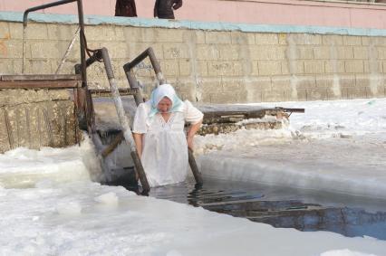 Женщина в платке и рубашке купается в проруби на Крещение, 19 января 2009 года, Саратов. Крещенские морозы, прорубь, купальник, грудь, девушка, снег, ледяная вода, обморожение, обряд, святая вода, купель.
