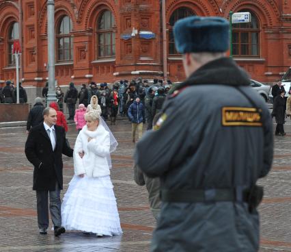 Россия. Москва. 15 января 2011. Манежная площадь, милиция, милиционер. Молодожены,  жених невеста.