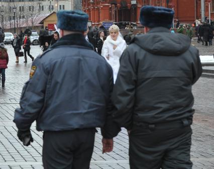 Россия. Москва. 15 января 2011. Манежная площадь, милиция, милиционер. Молодожены,  жених невеста.