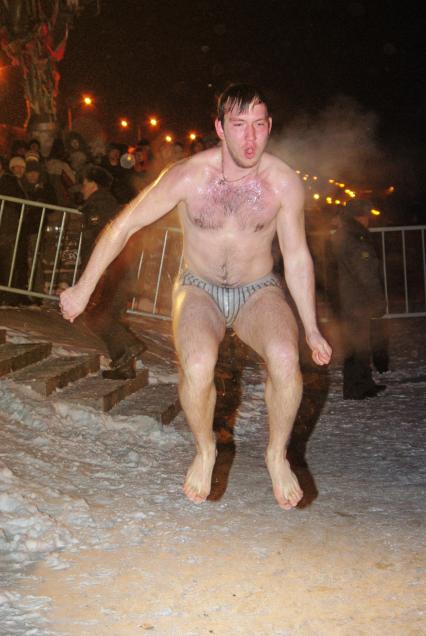 Мужчина прыгает у проруби в крещение, Саратов, 19 января 2011 года. Купель, крещение, мороз, зима, ледяная вода, закаливание, ночное купание, ночь, прорубь, холод, религия, оздоровление, вера.