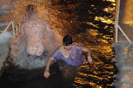 Мужчина и девушка купаются в проруби, Саратов, 19 января 2011 года. Купель, крещение, мороз, зима, ледяная вода, закаливание, ночное купание, ночь, прорубь, холод, религия, оздоровление, вера.