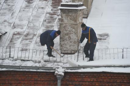 г. Москва.  Гастарбайтеры убирают снег с крыши многоэтажного дома 20 января 2011