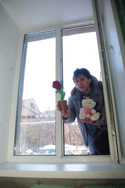 Молодой человек с цветами, подарками лезет в окно извиняться перед девушкой, Саратов, 27 января 2011 года. Отношения, мужчина и женщина, сорри центр.