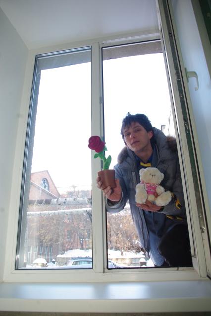 Молодой человек с цветами, подарками лезет в окно извиняться перед девушкой, Саратов, 27 января 2011 года. Отношения, мужчина и женщина, сорри центр.