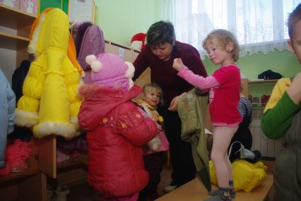 Дети в раздевалке детского сада переодеваются после прогулки на свежем воздухе, Саратов, 3 февраля 2011 года. Дети, детсад, детский сад, прогулка, одежда, зима, группа, воспитатель