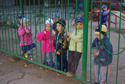 Дети стоят у забора в детском саду, Саратов, 25 сентября 2009 года. Детский сад, дети, забор, детсад, прогулка.