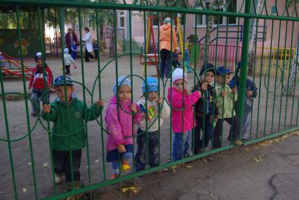 Дети стоят у забора в детском саду, Саратов, 25 сентября 2009 года. Детский сад, дети, забор, детсад, прогулка.